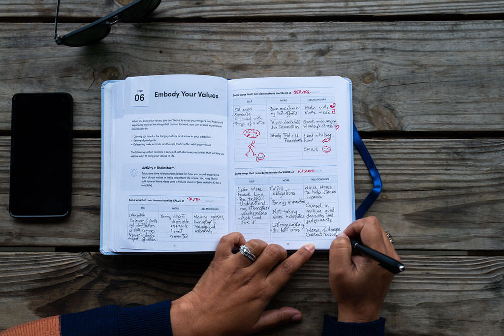 Woman writing in a BestSelf Co. journal